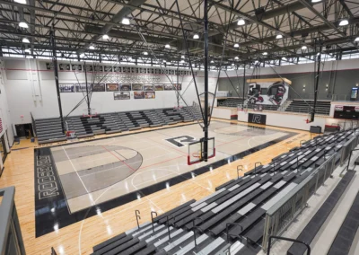 High School gymnasium telescoping bleachers with grey seat modules