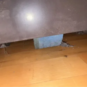 Damaged bleacher drive wheel in a school gymnasium.